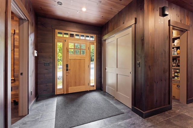 entryway with recessed lighting, wooden ceiling, and wood walls