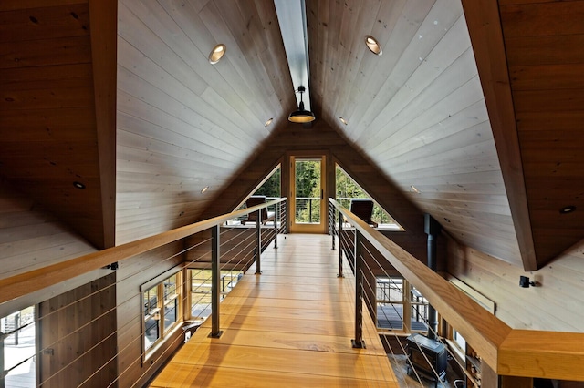 additional living space with wooden ceiling, hardwood / wood-style flooring, wooden walls, and lofted ceiling