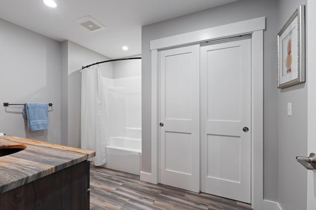 full bath featuring shower / bathtub combination with curtain, recessed lighting, wood finished floors, and vanity