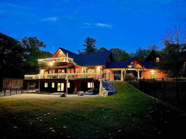 back of house with a deck, fence private yard, and a lawn