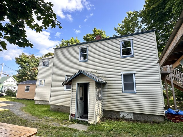 rear view of house featuring a yard and a deck