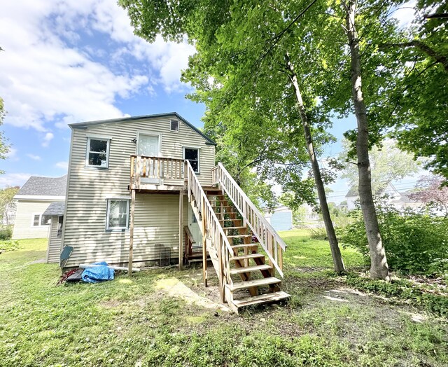 rear view of house with a yard and a wooden deck