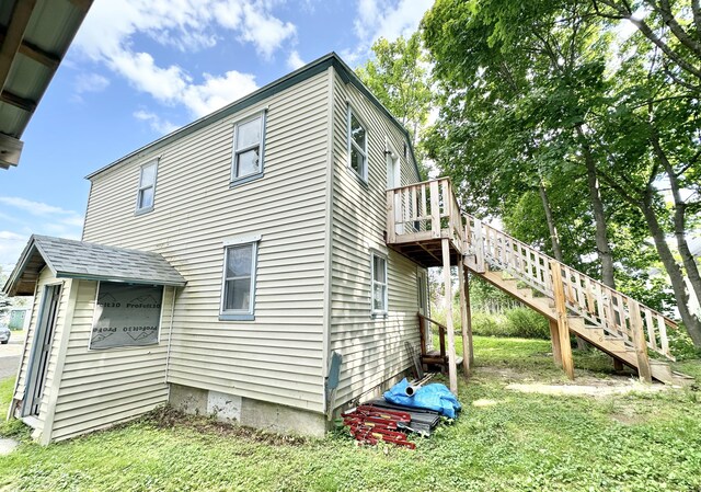 back of house with a wooden deck and a yard