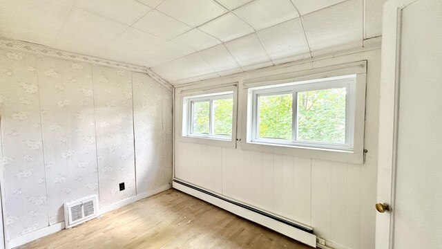 empty room with a baseboard heating unit and hardwood / wood-style flooring