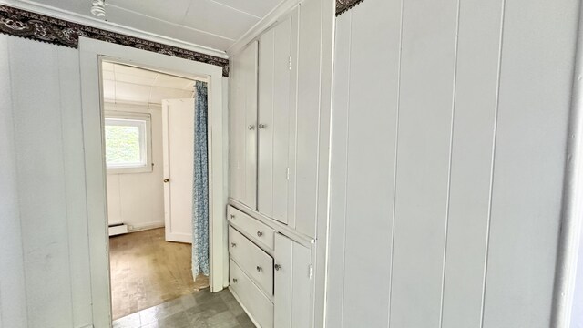 corridor featuring a baseboard radiator and wood-type flooring