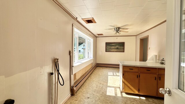 interior space with a baseboard heating unit, ceiling fan, and crown molding