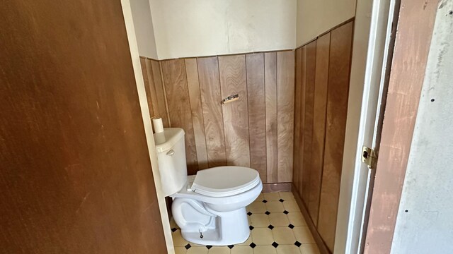 bathroom with toilet and wooden walls