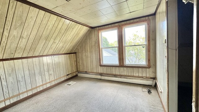 bonus room featuring baseboard heating, wooden walls, and carpet floors