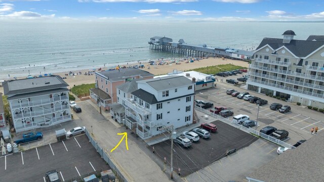 drone / aerial view featuring a beach view and a water view