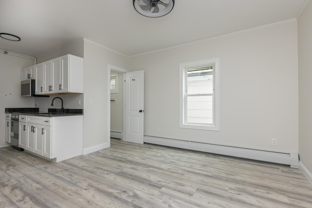 kitchen featuring a baseboard radiator, stainless steel appliances, white cabinets, light wood finished floors, and dark countertops