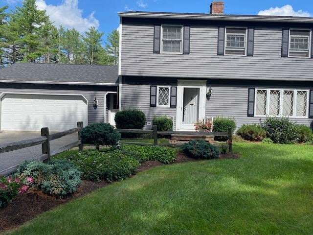 view of front of property featuring a garage and a front lawn