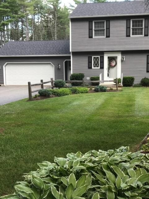 view of front of property with a garage and a front lawn