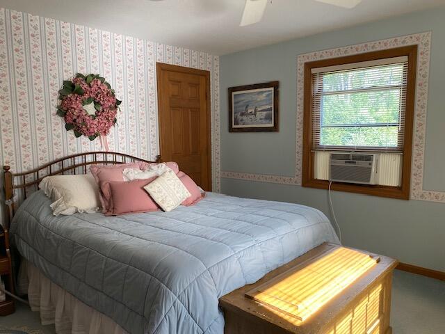 bedroom featuring cooling unit, ceiling fan, and carpet