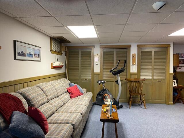 carpeted living room featuring a paneled ceiling