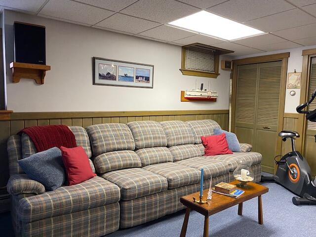 carpeted living room with a drop ceiling