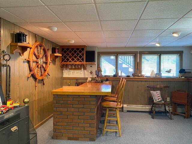 bar with a baseboard heating unit, wood counters, a paneled ceiling, and carpet floors