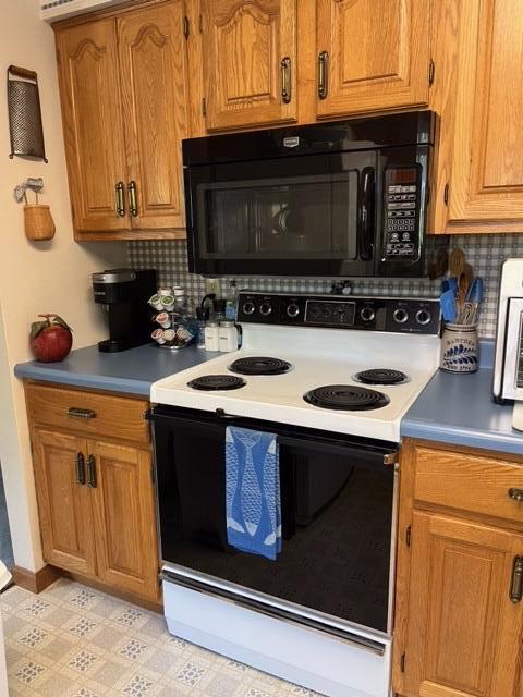 kitchen with white range with electric cooktop, light tile patterned floors, and backsplash