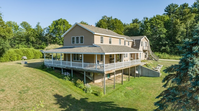 rear view of property with stairs, a shingled roof, and a lawn