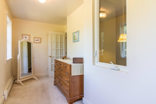corridor featuring light carpet, baseboards, and a baseboard heating unit