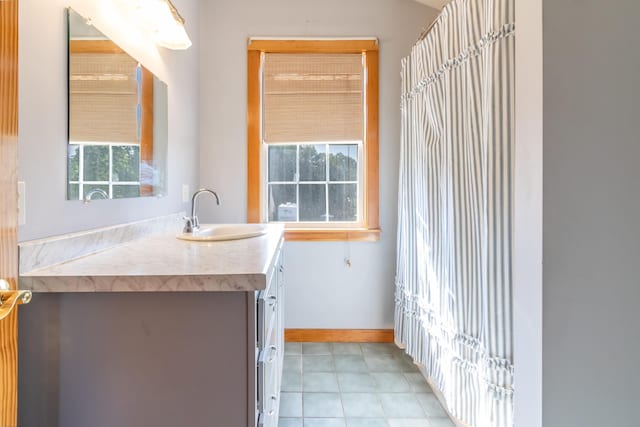 bathroom featuring baseboards, tile patterned flooring, and vanity