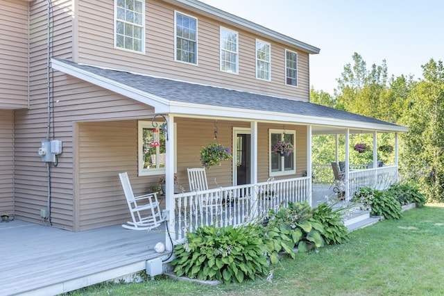 view of front facade featuring covered porch and a shingled roof