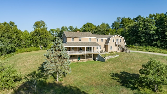 rear view of house featuring a gambrel roof, stairway, roof with shingles, and a lawn