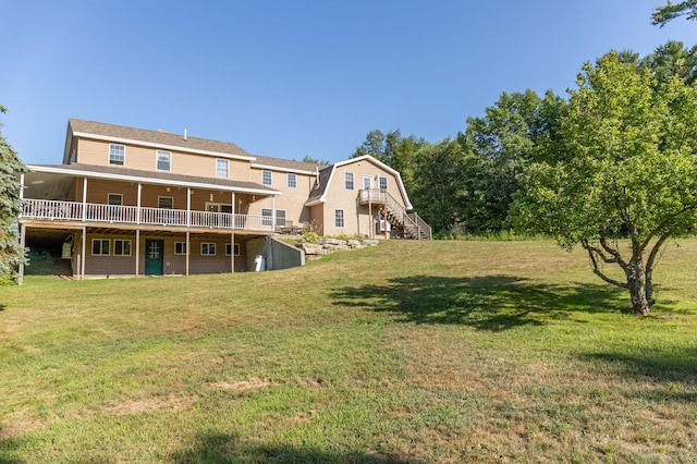 back of house featuring a gambrel roof, a lawn, a wooden deck, and stairs