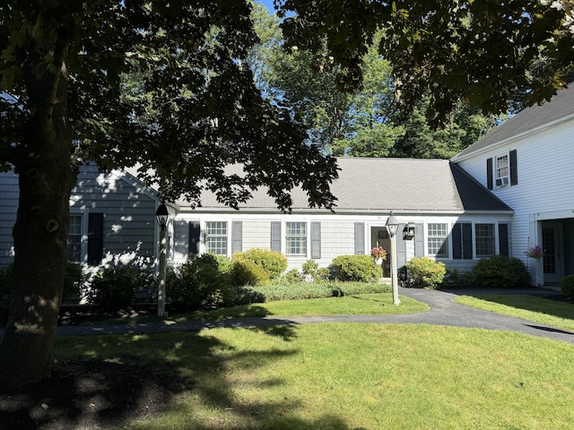 cape cod house featuring a front lawn