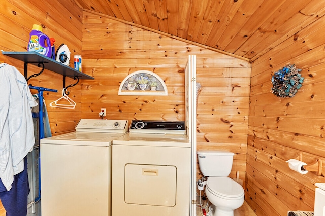 clothes washing area featuring wood ceiling, independent washer and dryer, and wooden walls