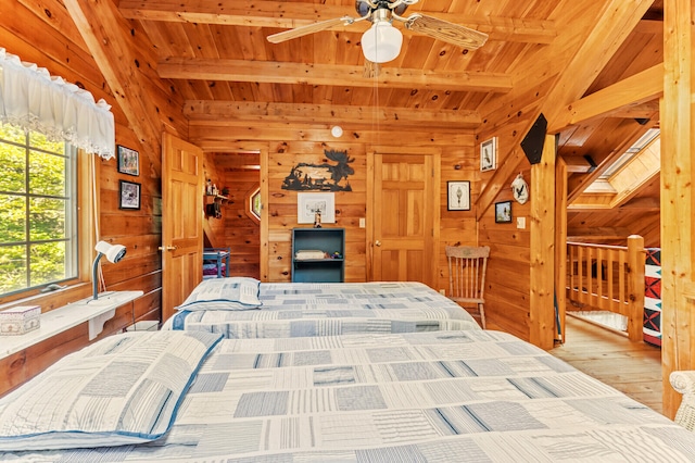 bedroom with light wood-type flooring, wood ceiling, wood walls, and beam ceiling