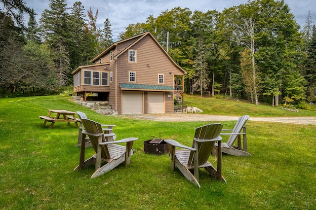 back of property featuring a lawn and a garage