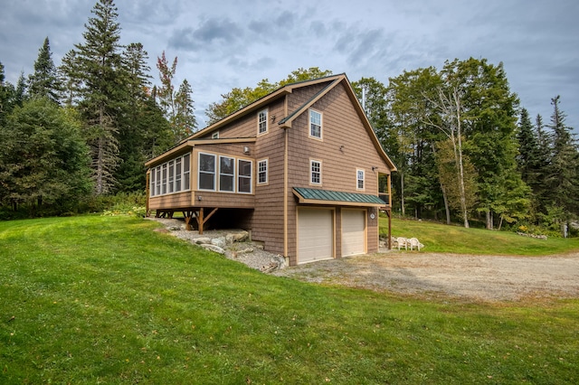 back of house featuring a garage and a yard