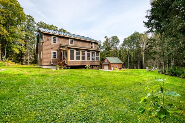 rear view of property featuring a sunroom and a yard