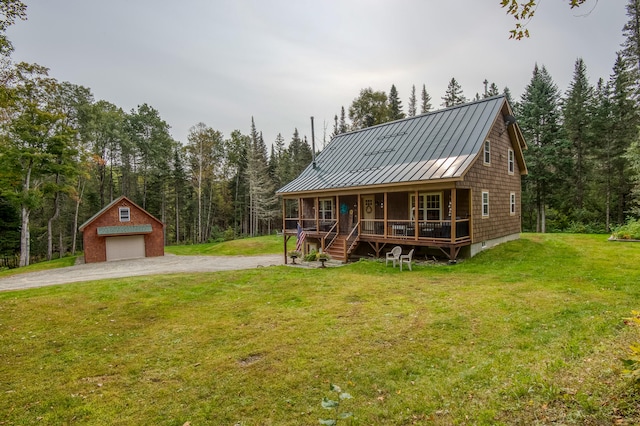 view of front of house featuring an outbuilding, a porch, a garage, and a front lawn