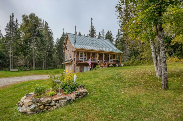 cabin with covered porch and a front yard