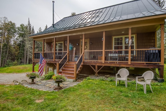 back of house featuring a lawn and covered porch