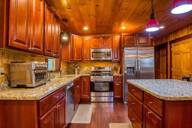 kitchen featuring pendant lighting, stainless steel appliances, dark wood-type flooring, and sink