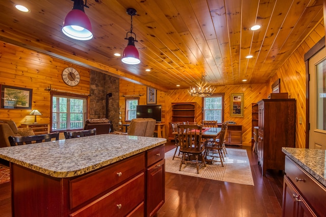 kitchen featuring pendant lighting, a kitchen island, wooden walls, dark wood-type flooring, and wooden ceiling