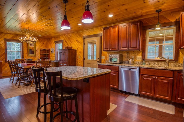 kitchen featuring wooden walls, dishwasher, sink, and dark hardwood / wood-style flooring