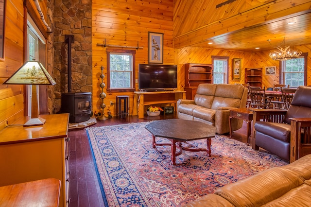 living room with wood ceiling, wood-type flooring, a wood stove, high vaulted ceiling, and wooden walls