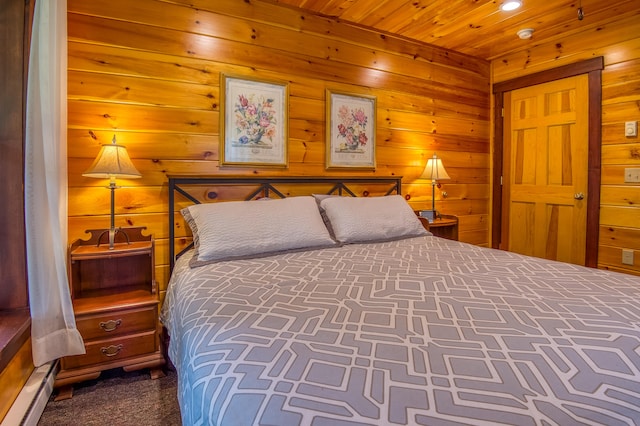 bedroom with wooden ceiling, wood walls, baseboard heating, and dark carpet