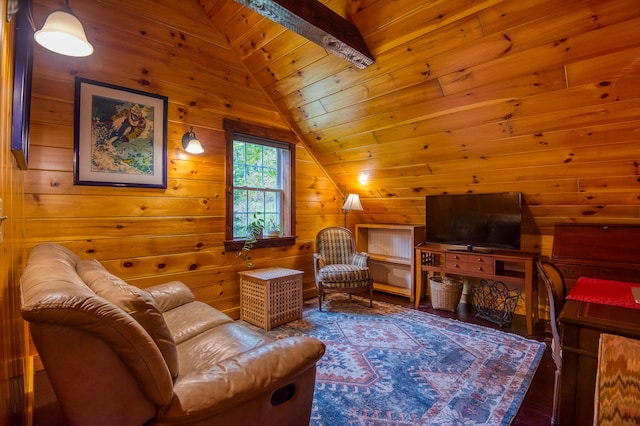 living area with vaulted ceiling with beams, wood walls, and dark hardwood / wood-style floors