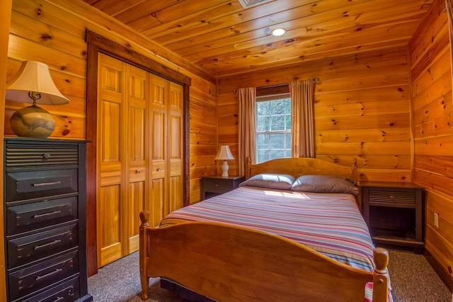 bedroom featuring wooden walls, dark colored carpet, a closet, and wooden ceiling