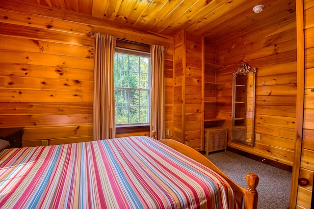 unfurnished bedroom with wood walls, wooden ceiling, and carpet floors