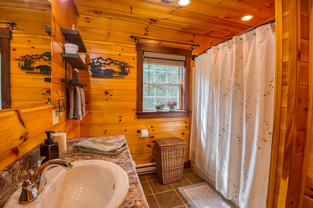 bathroom with vanity, wood ceiling, wooden walls, a baseboard heating unit, and tile patterned flooring