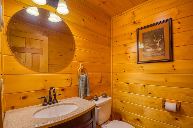 bathroom featuring wood ceiling, wooden walls, toilet, and vanity