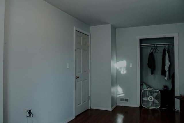 bedroom featuring dark hardwood / wood-style flooring and a closet