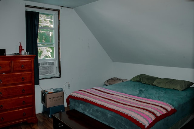 bedroom featuring cooling unit, lofted ceiling, and dark wood-type flooring