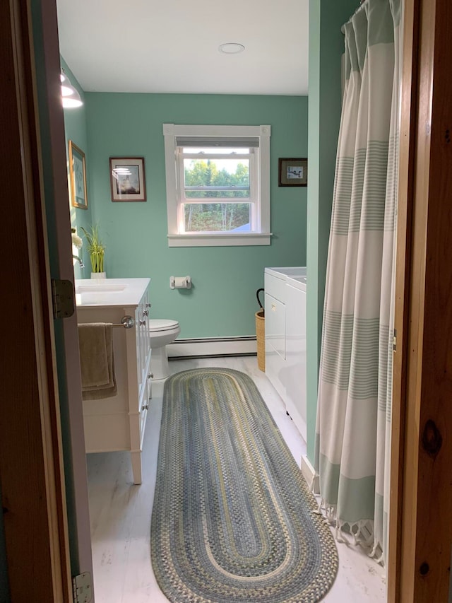 bathroom featuring curtained shower, vanity, toilet, and a baseboard heating unit