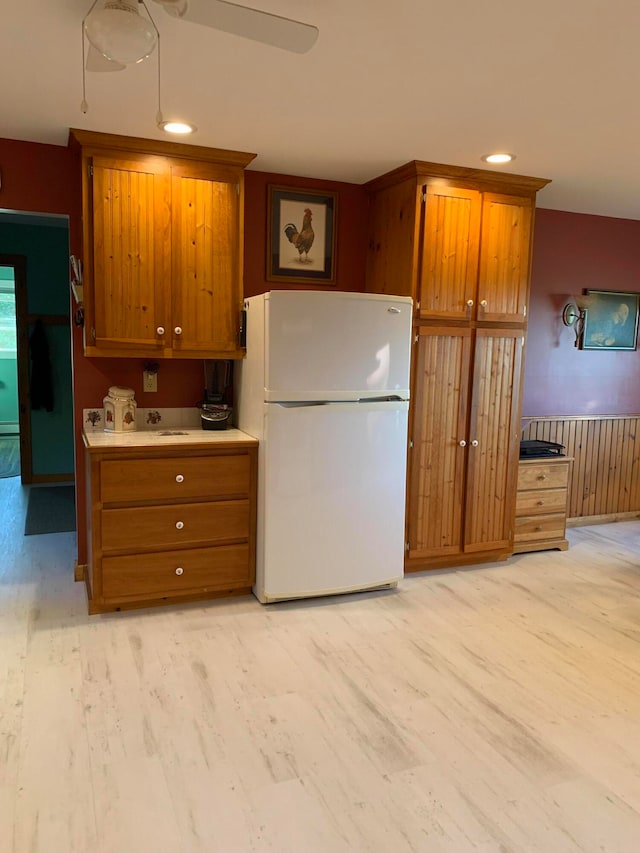 kitchen featuring light hardwood / wood-style flooring, ceiling fan, and white fridge